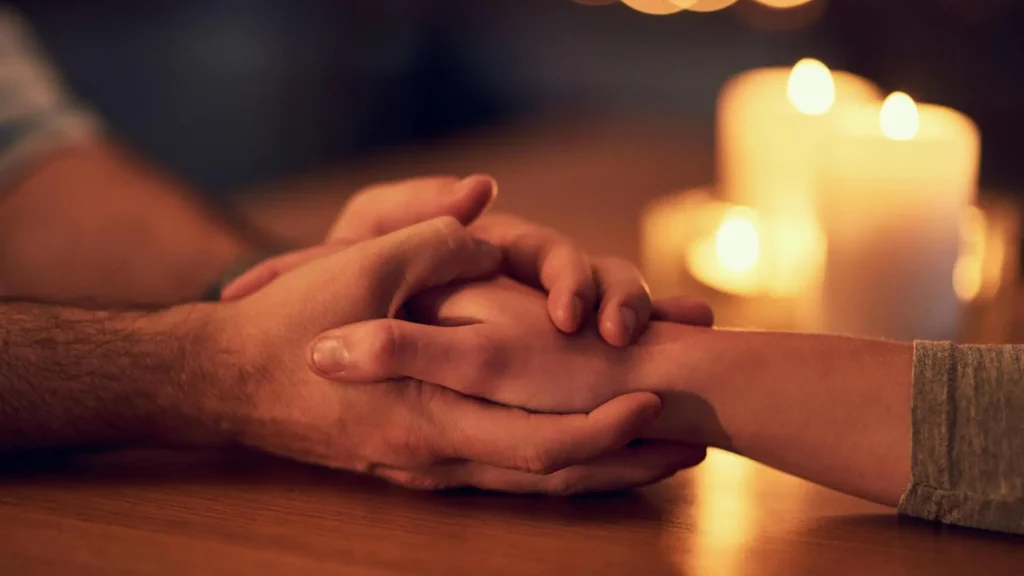 Żałoba po śmierci partnera – dwójka ludzi trzyma się za ręce, symbolika procesu żałoby